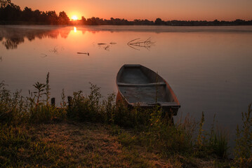 Łódka na tle wschodu słońca nad wodą, Polska, Śląsk.  © Elżbieta Kaps