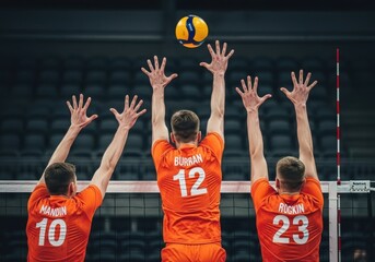 Volleyball players jump to block the ball in a competitive match action