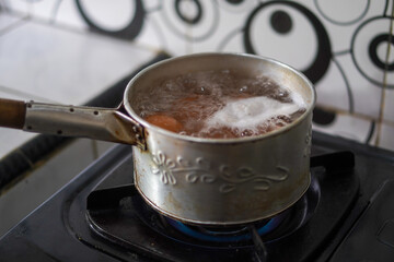The process of boiling eggs in a pan with boiling water