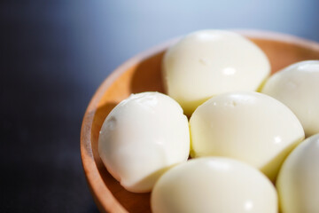 Closeup, Several boiled eggs in a wooden bowl on a black background
