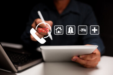 A person using a digital tablet with emergency icons including SOS, home, alert, ambulance, and...