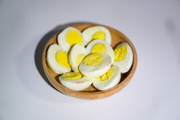 Boiled eggs that have been cut into two parts in a wooden bowl