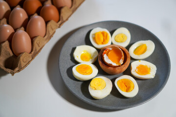 Various degrees of doneness of boiled eggs with a few whole eggs on top of the egg carpet