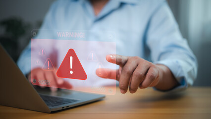 Person with holographic warning sign and red exclamation mark for cybersecurity threats