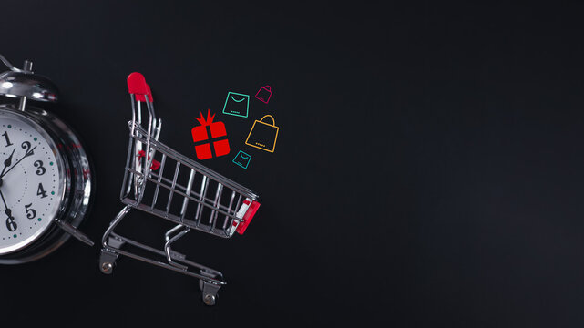 Mini shopping cart with alarm clock and holographic icons for urgent online shopping