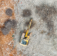Excavator with hydraulic hammer dismantling a building at a construction site