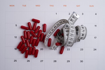 Measuring tape and tablets, vitamins on a light background with space for text. Concept of losing...