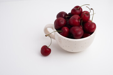Fresh cherries in a ceramic cup on the table. A handful of delicious berries. Antioxidants and vitamins