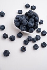Fresh organic blueberries in a plate on a light background. Antioxidants and vitamins