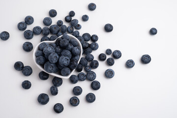 Fresh organic blueberries in a plate on a light background. Antioxidants and vitamins