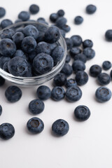 Fresh organic blueberries in a plate on a light background. Antioxidants and vitamins