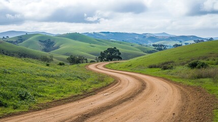Winding dirt road through grassy hills