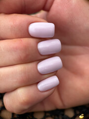 Close-up of light lilac pastel manicure on short nails. Elegant feminine hand styling ideal for beauty and nail inspiration themes.