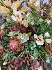 Dried flower arrangement with beige, white, and green tones. Includes artichoke flower and ornamental leaves, ideal for rustic or boho home decor concepts