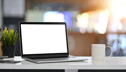 Laptop with blank screen and coffee mug.