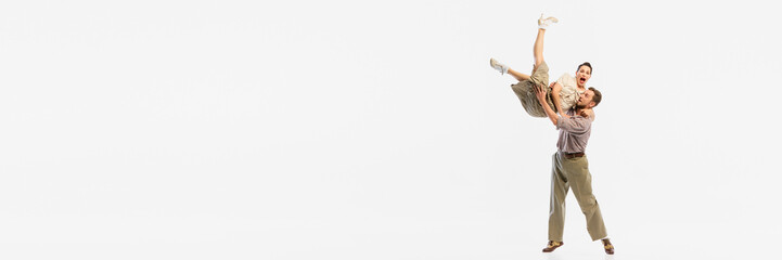 A retro dance couple performs an energetic lift against a white background. Concept of vintage...