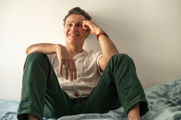 Obraz premium Smiling mature man relaxing on bed enjoying his free time