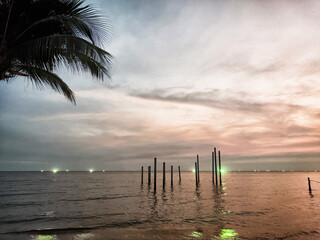 The breathtaking twilight casts a magical glow over the ocean, as the silhouettes of beachside...