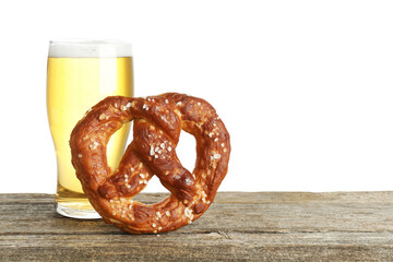 Tasty pretzel and glass of beer on wooden table against white background. Space for text