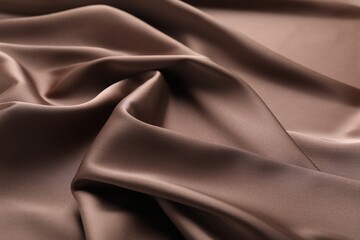 Crumpled light brown silk fabric as background, closeup