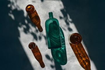 Artistic Still Life with Colored Glass Bottles and Shadow Play in Natural Light