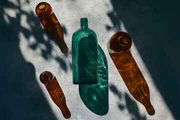 Artistic Still Life with Colored Glass Bottles and Shadow Play in Natural Light