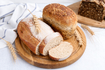 Freshly baked loaves of bread and spikes on light table, closeup