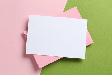 Blank invitation card and envelope on color background, top view. Space for design