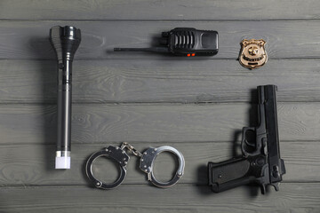 Different police equipment on grey wooden table, flat lay. Space for text