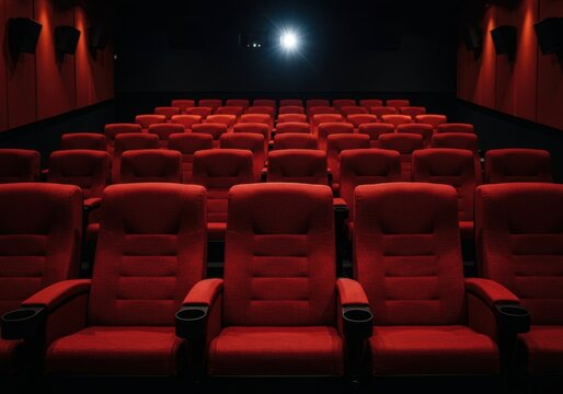 Empty movie theater with red seats and projector light in dark cinema hall