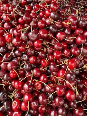 eap of fresh sweet cherries with stems. Rich red tones and glossy texture make them visually appetizing