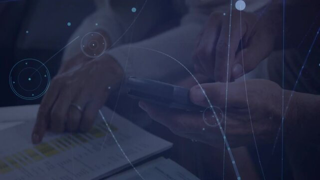 Senior professionals pointing spreadsheet row and tapping phone, generating 3D analytics overlays