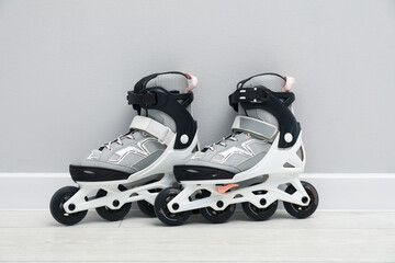 Pair of roller skates on floor near white wall