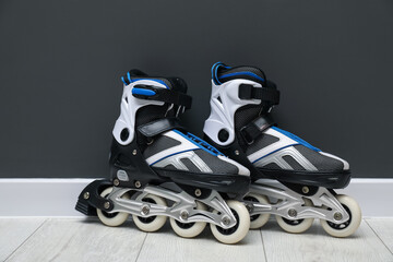 Pair of roller skates on floor near black wall