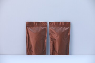 Two zipper stand-up pouches on light grey background. Mockup for design