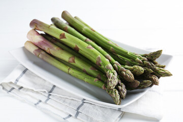 Fresh raw asparagus spears on white wooden table, closeup