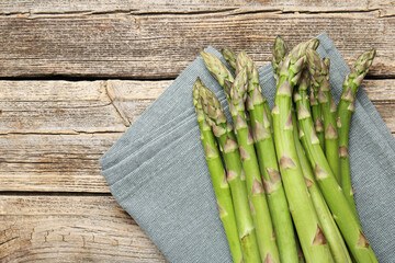 Fresh raw asparagus spears on wooden table, top view. Space for text