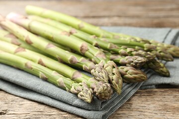 Fresh raw asparagus spears on wooden table, closeup