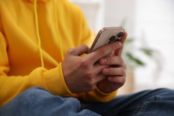Teenage boy using smartphone at home, closeup