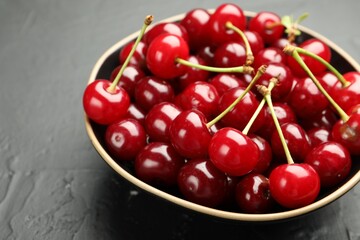 Fresh ripe cherries on black table, closeup