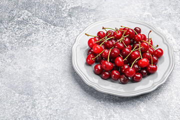 Wet ripe cherries on light table. Space for text