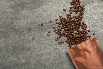 Zipper stand-up pouch and coffee beans on grey table, flat lay. Space for text