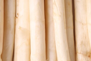 Raw white asparagus spears as background, closeup