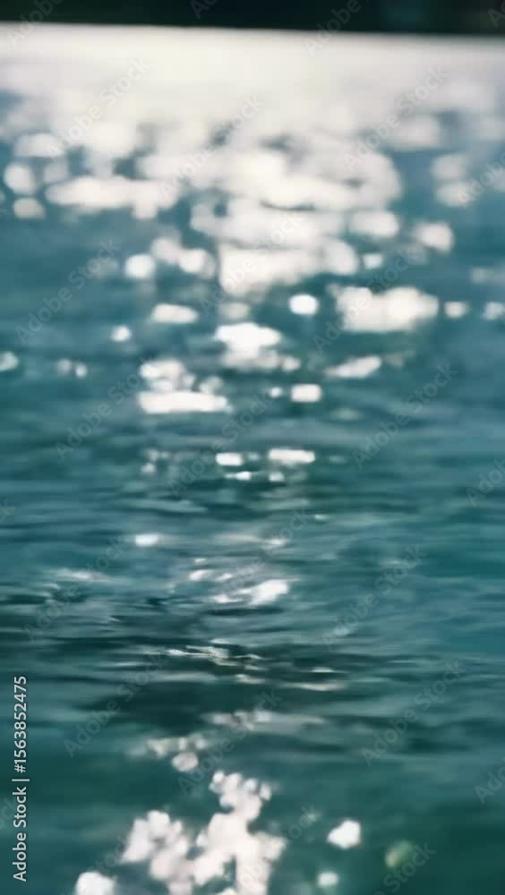 Poster Extreme close-up of a vibrant aquamarine water surface with iridescent white and golden light patterns dancing from direct sunbeams, creating a mesmerizing fluid mosaic with soft bokeh from deeper
