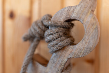 Close-up of a rope tied to an anchor, used as a decorative element. Nautical-themed decor symbolizing strength, stability, and marine heritage, ideal for coastal or maritime interior designs © Serhii