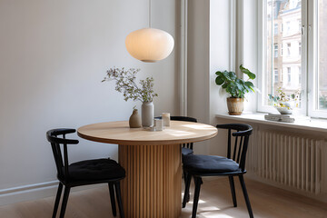 Obraz premium Light wood round dining table with black chairs and pendant light round table wood table