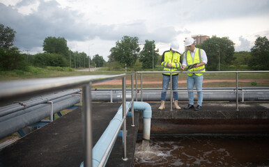 Two engineers are inspecting the operation of the treatment pond and checking the equipment