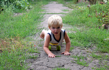 A small child is riding a skateboard lying down.