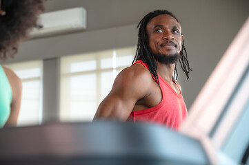 Strong muscular black sportsman jogging on treadmill training in gym