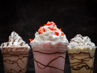 Milkshakes of different flavors on a dark background.